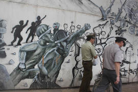 Carabineros frente a mural de trabajadores unidos en la lucha
