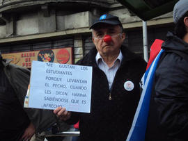 Hombre sosteniendo cartel "ME GUSTAN LOS ESTUDIANTES PORQUE LEVANTAN EL PECHO CUANDO LES DICEN HARINA SABIÉNDOSE QUE ES AFRECHO"
