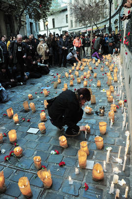Mujer encendiendo vela en frontis de Londres 38 durante conmemoración del 11 de septiembre