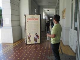 Persona observando la exposición itinerante "Montajes comunicacionales del pasado y del presente"