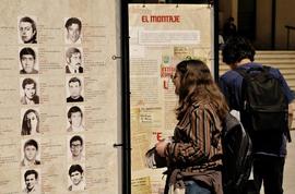 Persona observando la exposición itinerante "Montajes comunicacionales del pasado y del presente"