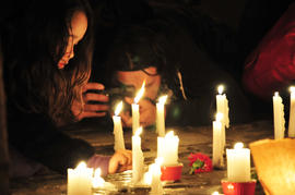 Niña encendiendo vela en frontis de Londres 38 durante conmemoración del 11 de septiembre