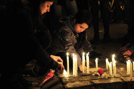 Mujer encendiendo vela en frontis de Londres 38 durante conmemoración del 11 de septiembre