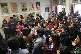 Personas escuchando charla sobre exposición de afiches