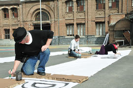 3 personas preparando lienzos para la intervención urbana "Puentes de la Memoria"