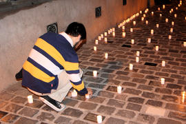 Hombre dejando vela en Londres 38 durante conmemoración del 11 de septiembre