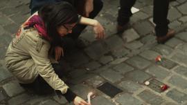 Mujer dejando vela en actividad conmemorativa por el Golpe de Estado en Chile